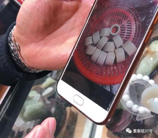 ▲2018年12月22日,广西浦寨口岸的玉石珠宝商潘文斌向记者展示其走私同伙发来的现代象牙制品。 新京报记者王嘉宁 摄